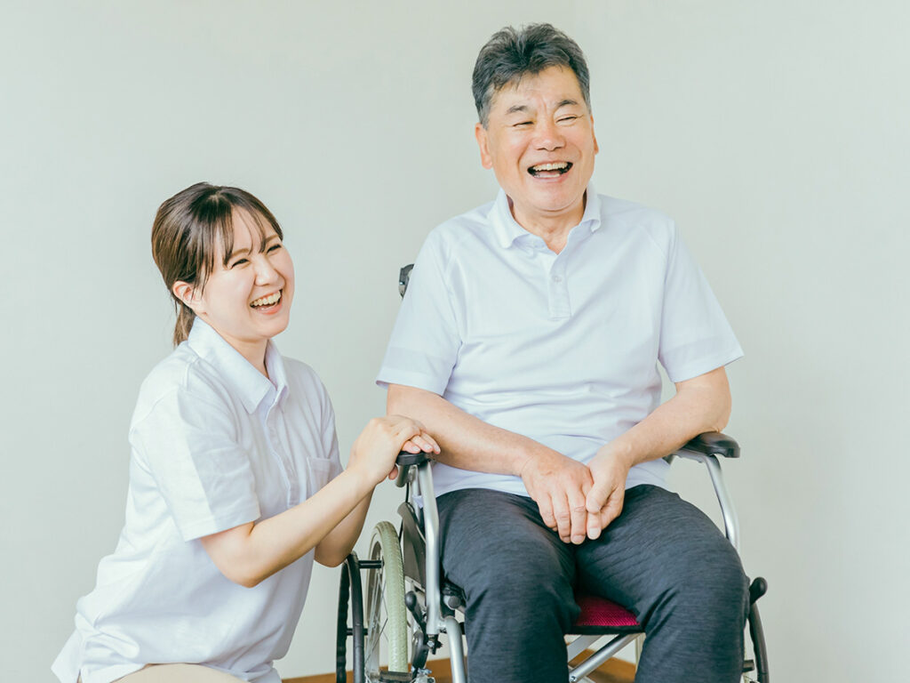 笑顔の車椅子男性と看護師